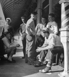 a group of men standing next to each other in front of a train station building