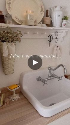 a white sink sitting on top of a wooden counter next to a shelf filled with dishes