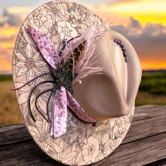 Indulge in the bohemian charm of our Floral Wide Brim Burned Hat, meticulously hand-drawn and adorned with feather, ribbon, and stone accents. Featuring an adjustable hat band for a perfect fit, this one-size-fits-most hat measures approximately 15 x 15 with a stylish 4" brim. Elevate your look with this unique accessory that exudes elegance and individuality. Boho Chic Hats, Boho Cowgirl Style, Black Fedora Hat, Band Ideas, Hat Bands, Rancher Hat, Boho Cowgirl, Boho Hat, Fancy Hats