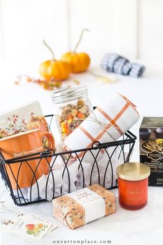 a basket filled with lots of different items on top of a white table next to some cards