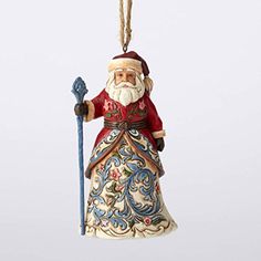 a ceramic ornament with a santa clause holding a blue staff and wearing a red hat