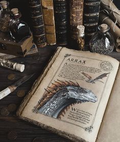 an open book sitting on top of a wooden table next to books and other items