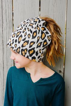 a woman wearing a leopard print beanie with her hair in a pony tail ponytail