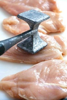 raw chicken being used as meat cleaver on white plate