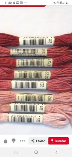 three skeins of red and pink yarn on a white background with bar code