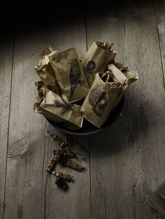 a bowl filled with lots of brown bags on top of a wooden floor next to a laptop