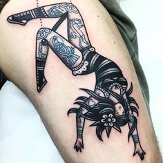 a woman with tattoos on her arm and leg is holding a knife in the air