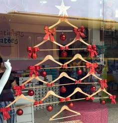 there is a christmas tree in the shop window with red and white bows on it