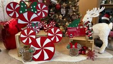 christmas decorations are displayed in front of a tree and other holiday items on the floor