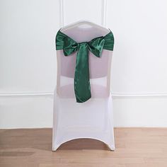 a chair with a green bow tied to it's back on a wooden floor