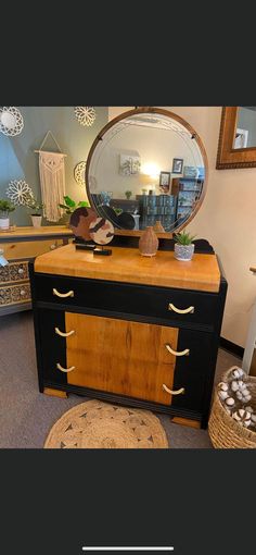 a dresser with a mirror on top of it next to a rug and other items