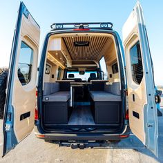 the back end of a van with its doors open and two seats folded up in front