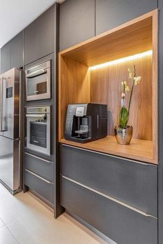 a modern kitchen with stainless steel appliances and wood paneling, including a microwave oven