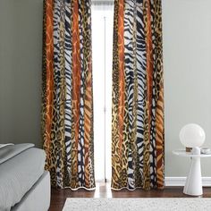 the curtains in this bedroom are made up of different colors and patterns, including zebra print