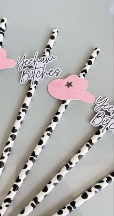 black and white polka dot straws with pink heart shaped top on grey background for valentine's day