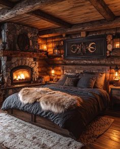 a rustic bedroom with stone fireplaces and wood flooring is lit up by candles