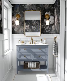 a bathroom with a blue vanity and floral wallpaper on the walls, along with a gold framed mirror