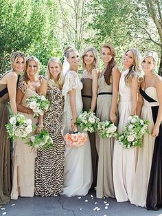 a group of women standing next to each other holding bouquets in front of them