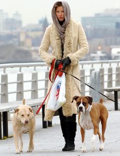 a woman walking two dogs on a leash