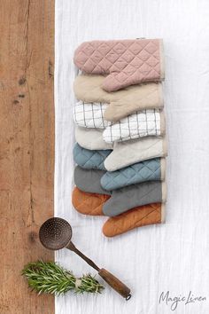 a pile of folded towels sitting on top of a table next to a wooden spoon