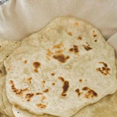 three tortillas sitting on top of each other in a white paper wrapper