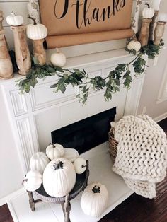 a fireplace mantel decorated with white pumpkins and greenery in front of a thank you sign