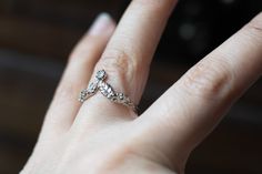 a woman's hand with a diamond ring on top of her finger, showing the middle finger