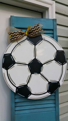 a painted soccer ball hanging on the side of a door with a burlock