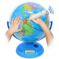 a child's hands holding a remote control on top of a globe