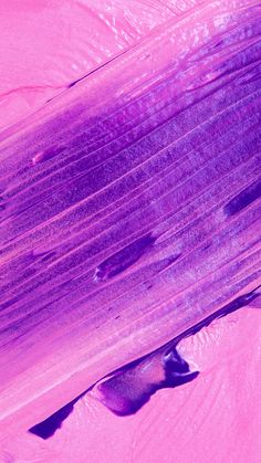 a close up view of the surface of an object with pink and purple paint on it