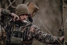 a man in camouflage aiming at an arrow