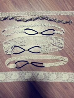 three pieces of white lace with black bows and eyeglasses on the top one