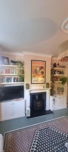 a living room filled with furniture and a flat screen tv mounted on a wall above a fire place