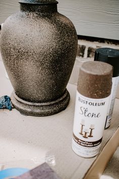 a vase sitting on top of a table next to a spray bottle and some other items