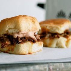 three mini sandwiches sitting on top of a piece of paper