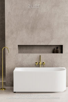 a white bath tub sitting next to a wall mounted faucet in a bathroom