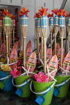 there are many small buckets with surfboards in them and flowers on the top