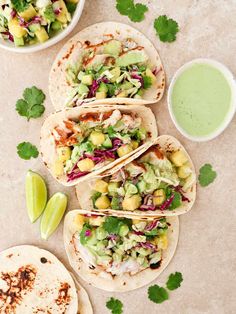 three tacos with avocado, lettuce and pineapple salsa on the side