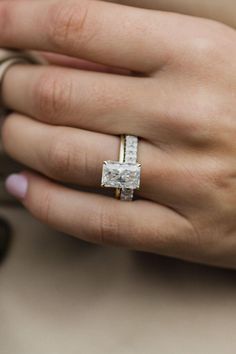 a woman's hand with a diamond ring on it