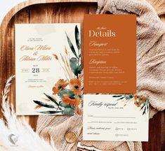 an orange and white floral wedding suite on top of a wooden table with feathers, money and other items