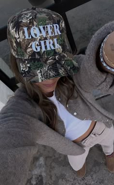 Preorder tees and sweatshirts ship out within 2-12 business days and preorder hats can take up to 15 business days to ship. Camo is the new pink! Rock this trendy camo trucker hat this Valentine's Day - we can guarantee your guy will think it's the coolest. ALL HATS ARE FINAL SALE! Camo Hats Outfits, Trucker Hat Outfit, Cowgirl Era, Girl Trucker, Girl Camo, Camo Trucker Hat, Hat Bar, Girl Western, Custom Trucker Hats