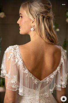 a woman in a wedding dress looking off into the distance with her back to the camera