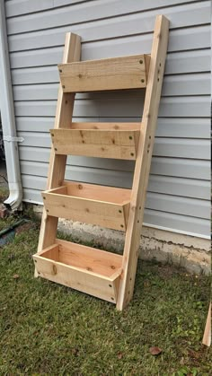 a wooden ladder sitting in the grass next to a building