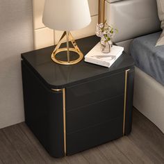 a nightstand with a lamp on it next to a bed