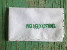 an embroidered napkin that says nollycrine on it, sitting on a wooden surface