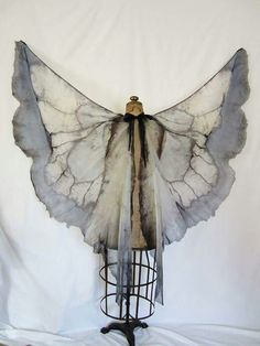 a white and gray butterfly wings on a mannequin