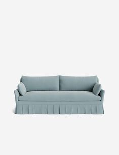 a light blue couch with pleated cushions