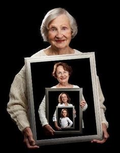 an old woman holding up a framed photo with the words in arabic and english on it