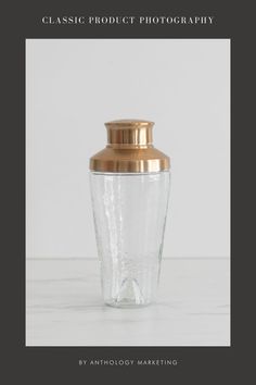 a glass jar with a gold lid sitting on top of a table