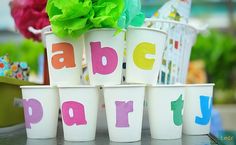 plastic cups with letters and flowers in them